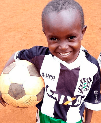 A smiling boy holding a soccer ball