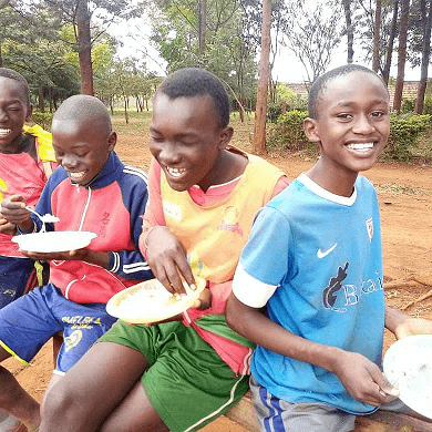 Boys laughing while eating