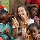 Volunteer and children showing freshly painted nails