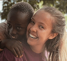 Volunteer laughing with African children